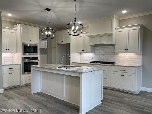 kitchen featuring built in microwave, sink, oven, pendant lighting, and white cabinets