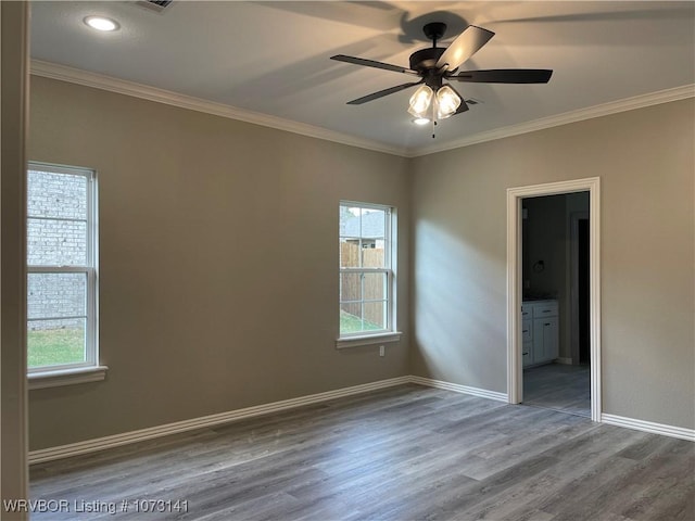 unfurnished room featuring ornamental molding, hardwood / wood-style flooring, ceiling fan, and a healthy amount of sunlight