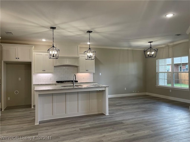 kitchen featuring white cabinetry, sink, light stone countertops, dark hardwood / wood-style flooring, and a kitchen island with sink