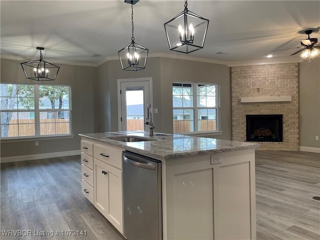 kitchen featuring white cabinetry, dishwasher, pendant lighting, and a center island with sink