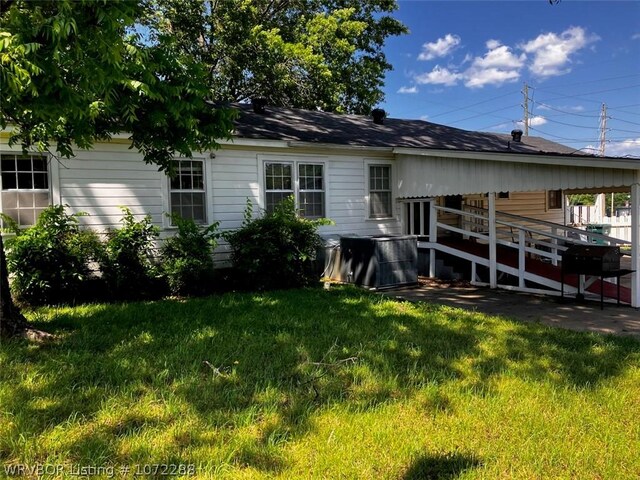 back of property with a lawn and a wooden deck