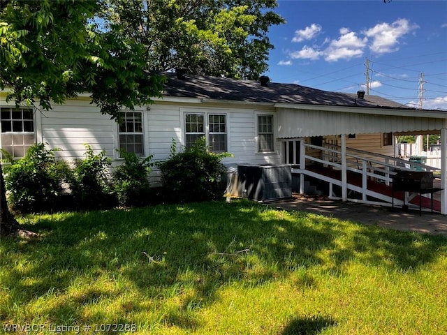 back of house with a deck and a lawn