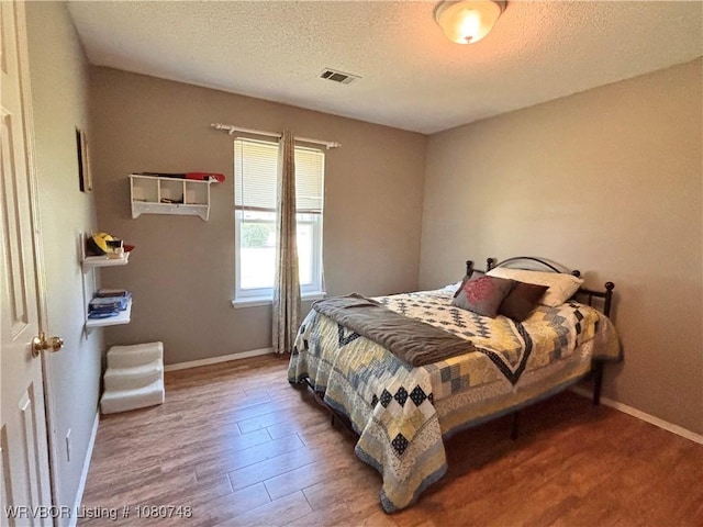 2114 Breckenridge Ter, Greenwood, AR 72936 - bedroom with wood finished floors, a textured ceiling, and baseboards