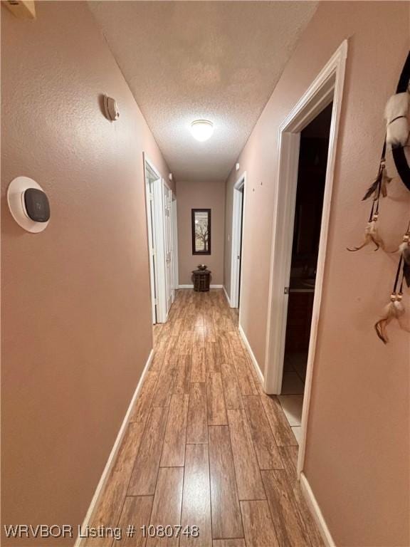 2114 Breckenridge Ter, Greenwood, AR 72936 - hallway featuring light wood-type flooring, a textured ceiling, and baseboards