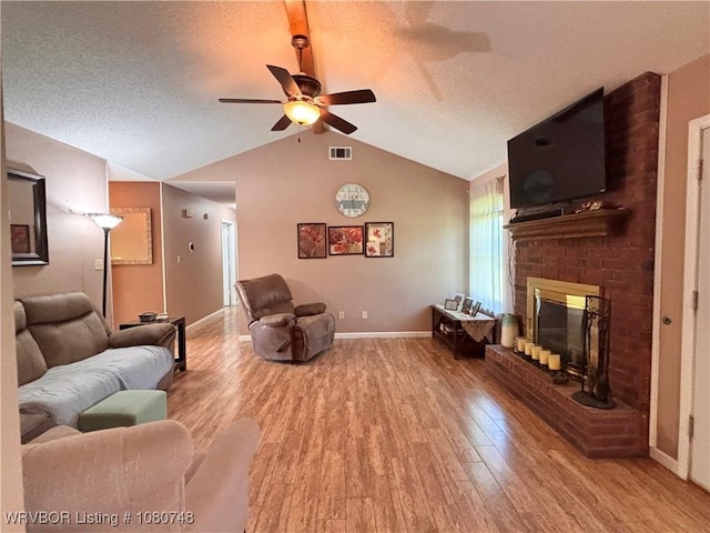 2114 Breckenridge Ter, Greenwood, AR 72936 - living area featuring wood finished floors, ceiling fan, vaulted ceiling, a textured ceiling, and a brick fireplace