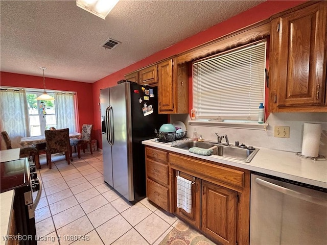 2114 Breckenridge Ter, Greenwood, AR 72936 - kitchen with stainless steel appliances, a sink, light countertops, brown cabinets, and a textured ceiling