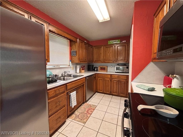 2114 Breckenridge Ter, Greenwood, AR 72936 - kitchen with appliances with stainless steel finishes, a sink, light countertops, brown cabinets, and a textured ceiling
