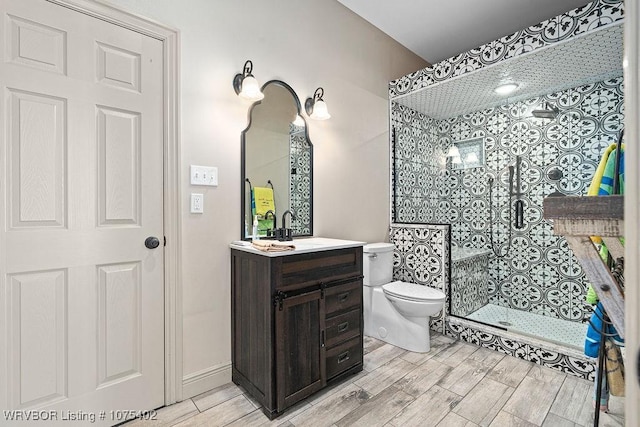 bathroom featuring tiled shower, vanity, and toilet