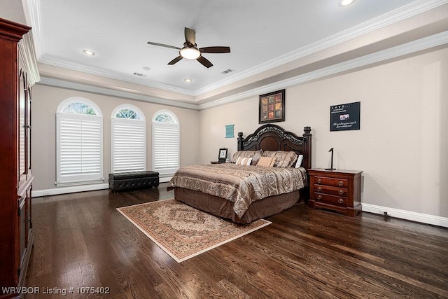 bedroom with dark hardwood / wood-style floors, ceiling fan, crown molding, and a tray ceiling