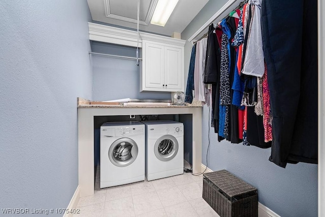 clothes washing area featuring washing machine and clothes dryer and cabinets