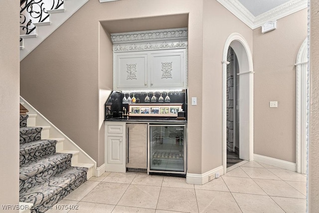 kitchen featuring wine cooler, crown molding, and light tile patterned floors