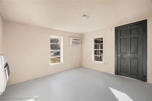 spare room with heating unit and a wall mounted air conditioner