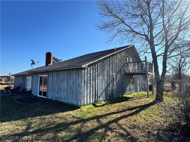 view of side of home with a yard