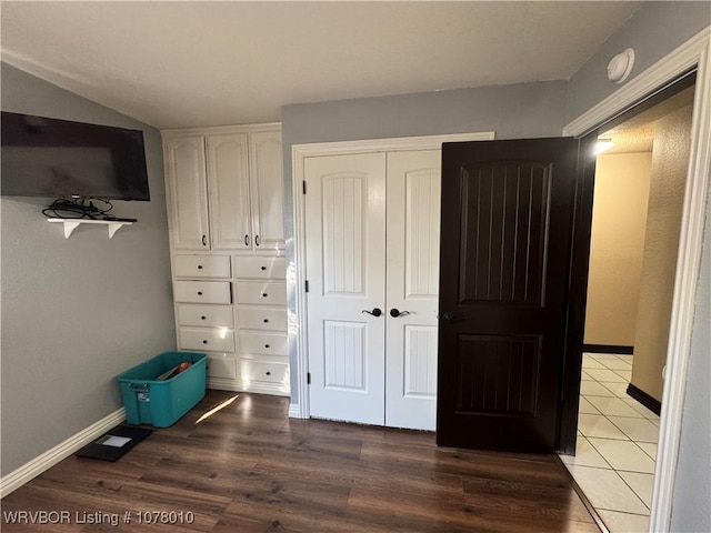 unfurnished bedroom with a closet and dark wood-type flooring