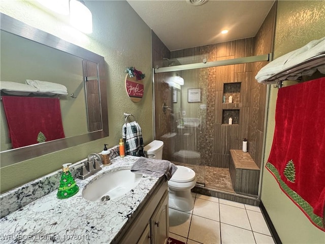 bathroom with tile patterned flooring, vanity, toilet, and a shower with door