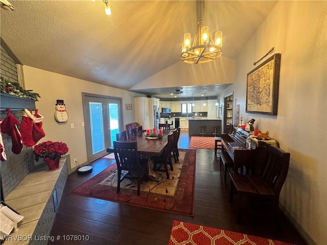 dining room with a chandelier, a textured ceiling, dark hardwood / wood-style flooring, and vaulted ceiling