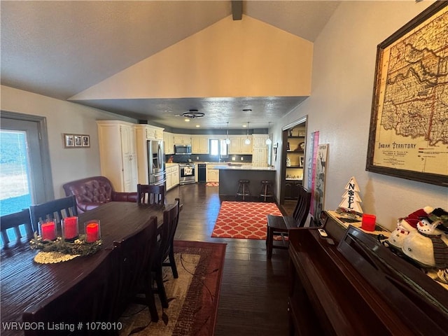 dining area featuring lofted ceiling with beams and dark wood-type flooring