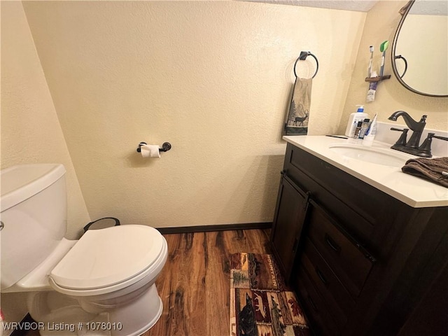 bathroom with hardwood / wood-style floors, vanity, and toilet