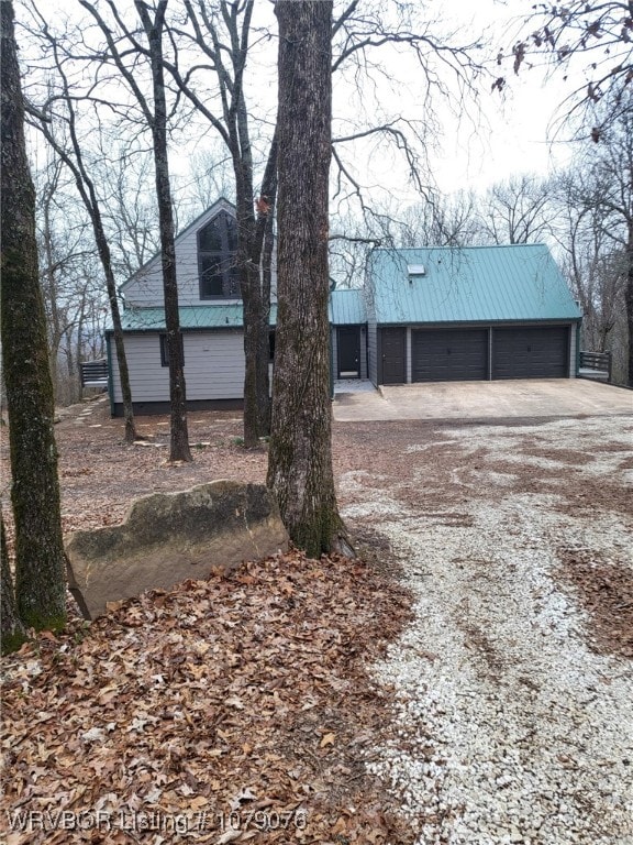 exterior space with a garage and metal roof