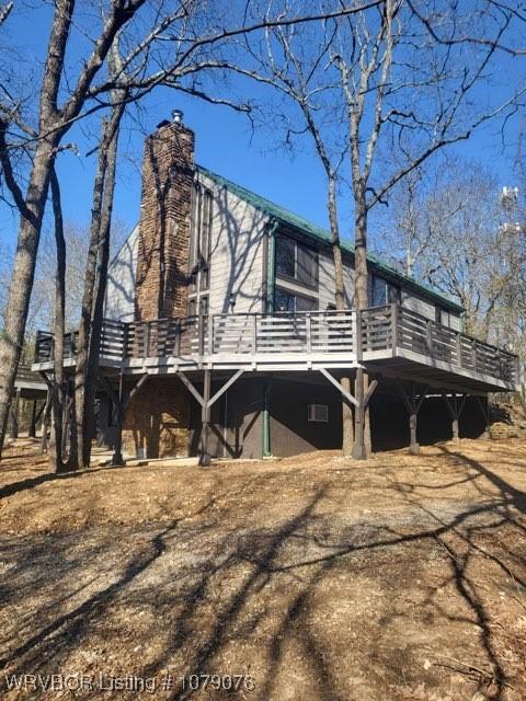 view of home's exterior with a deck and a chimney