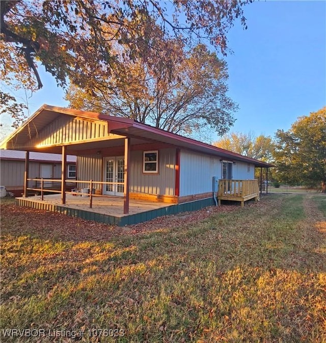 back of property with a yard and french doors