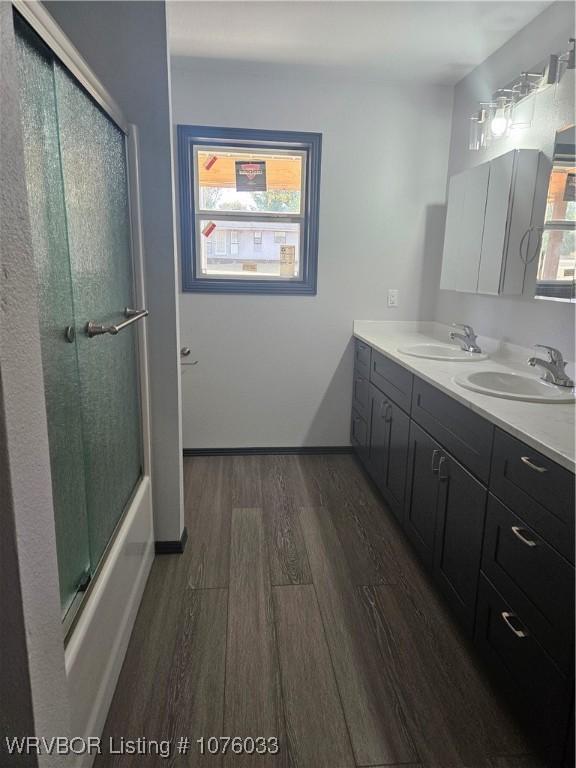 bathroom with vanity, enclosed tub / shower combo, and hardwood / wood-style flooring