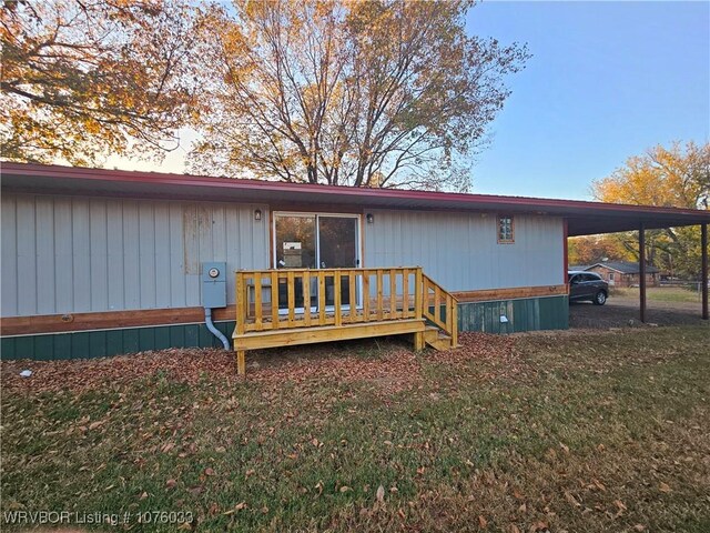 rear view of house with a carport and a yard