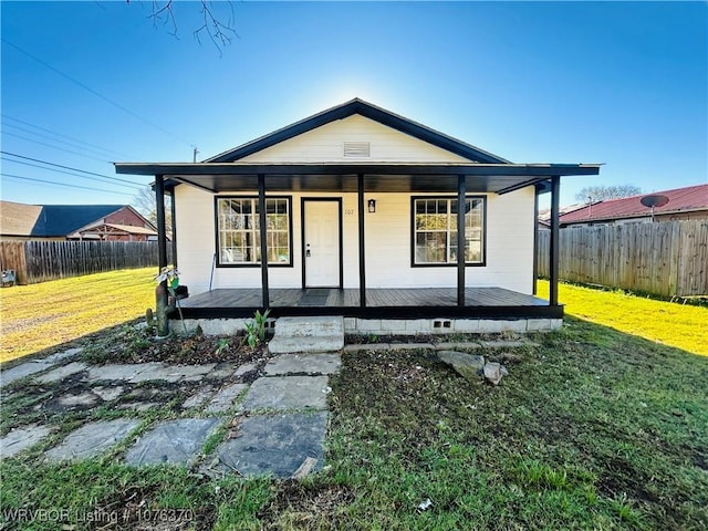 bungalow-style home featuring covered porch and a front yard