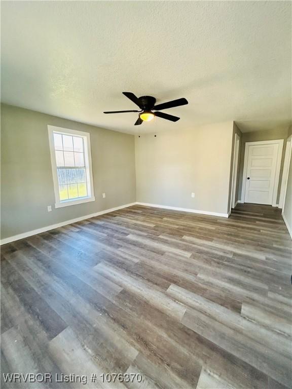 empty room with hardwood / wood-style floors, ceiling fan, and a textured ceiling