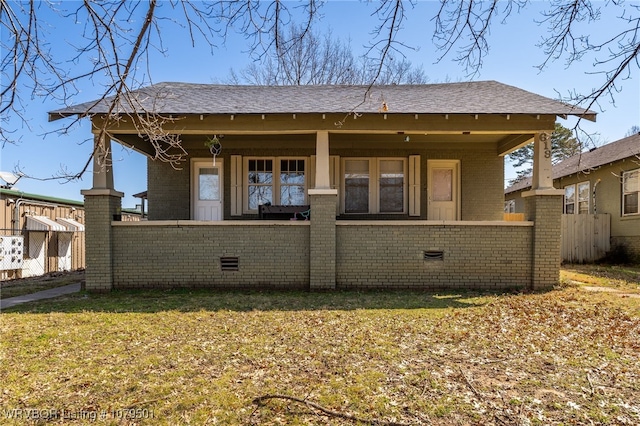 rear view of house featuring brick siding and a lawn