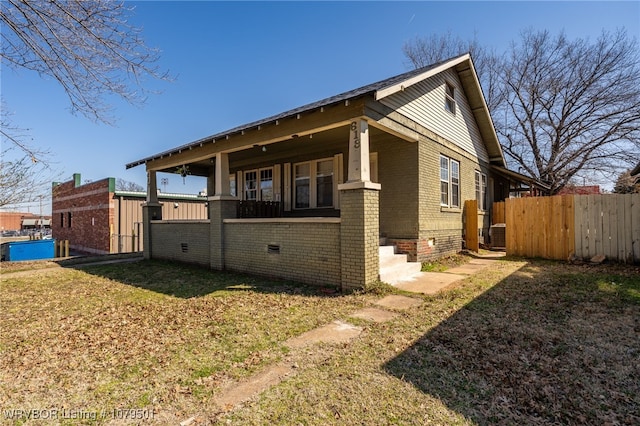 exterior space with brick siding, central air condition unit, a lawn, and fence