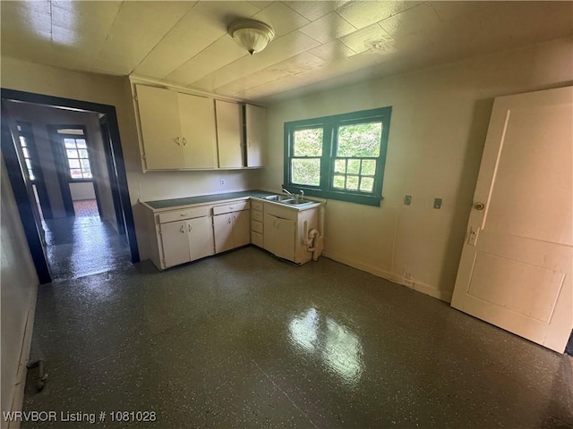 1025 Henry St, Alma, AR 72921 - kitchen with white cabinets, baseboards, a sink, and light countertops