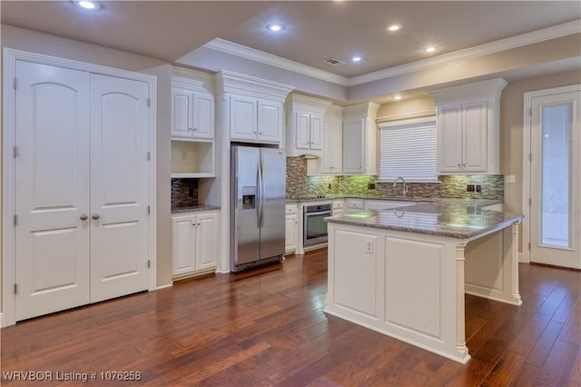 kitchen featuring a kitchen breakfast bar, light stone counters, white cabinetry, and appliances with stainless steel finishes