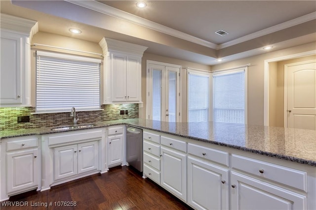 kitchen with light stone countertops, tasteful backsplash, sink, dishwasher, and white cabinets