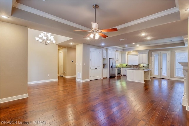 unfurnished living room with crown molding, dark hardwood / wood-style floors, a raised ceiling, and sink