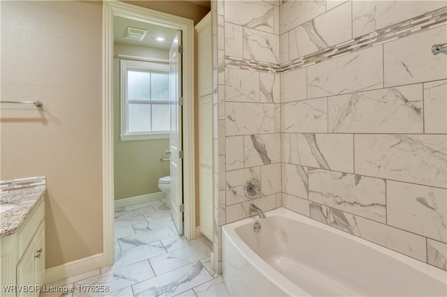 full bathroom with vanity, tiled shower / bath combo, and toilet