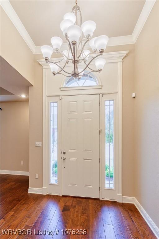 foyer entrance with a chandelier, dark hardwood / wood-style floors, and a wealth of natural light