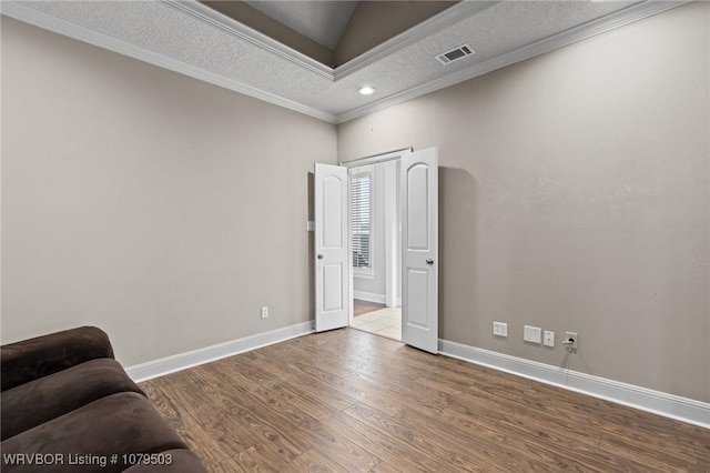 sitting room featuring visible vents, crown molding, baseboards, wood finished floors, and a textured ceiling