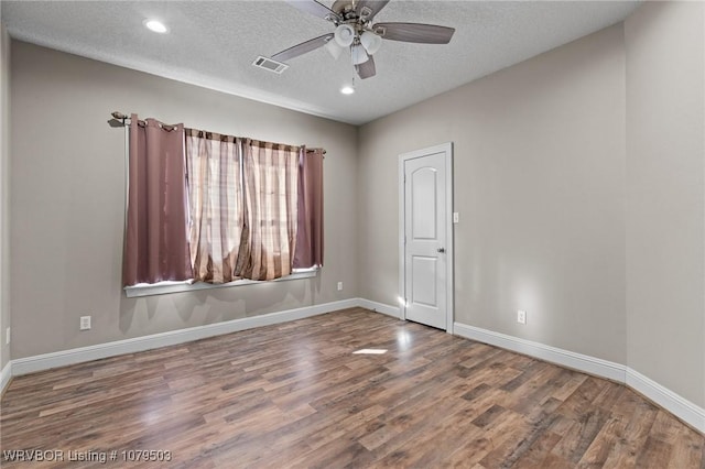 unfurnished room featuring visible vents, baseboards, wood finished floors, a textured ceiling, and a ceiling fan