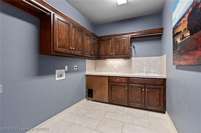 laundry area with baseboards, cabinet space, electric dryer hookup, washer hookup, and a sink