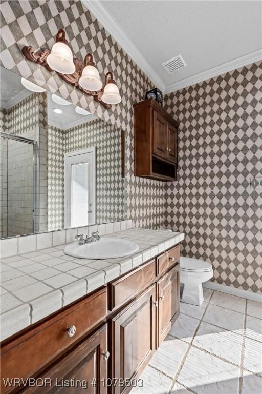 bathroom featuring visible vents, a shower stall, wallpapered walls, crown molding, and vanity