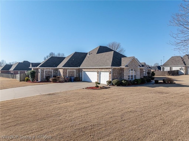 view of front of home featuring a front yard, fence, driveway, an attached garage, and stone siding