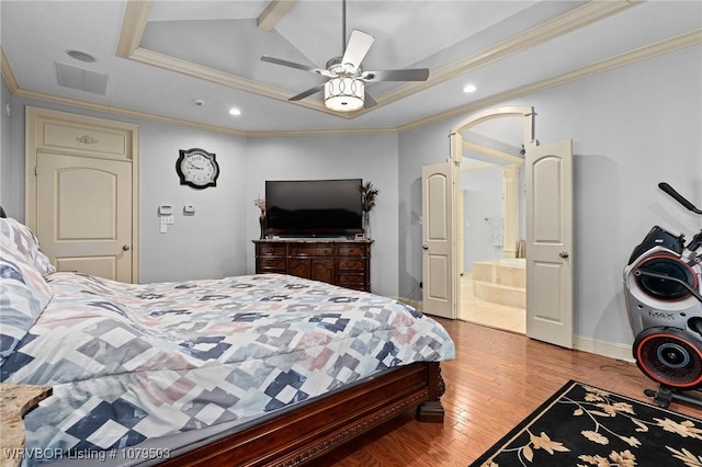 bedroom with arched walkways, wood finished floors, visible vents, and ornamental molding