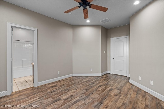 unfurnished bedroom featuring visible vents, recessed lighting, baseboards, and wood finished floors