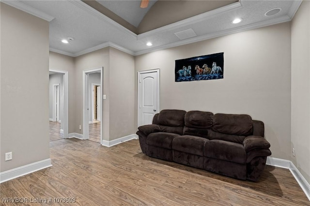 living room with recessed lighting, wood finished floors, baseboards, and ornamental molding