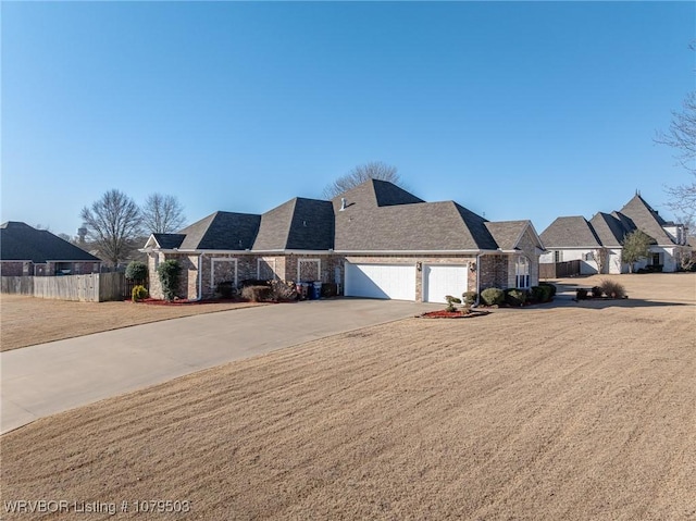 view of front facade featuring a front lawn, concrete driveway, a garage, and fence