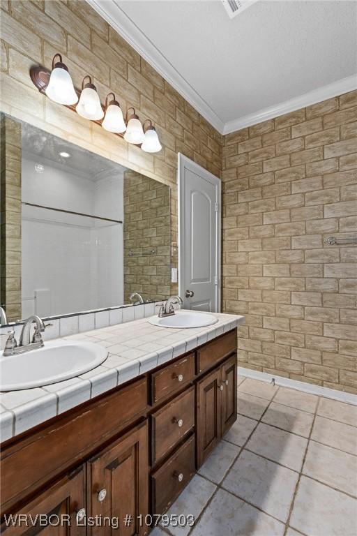 full bath featuring a sink, double vanity, and crown molding