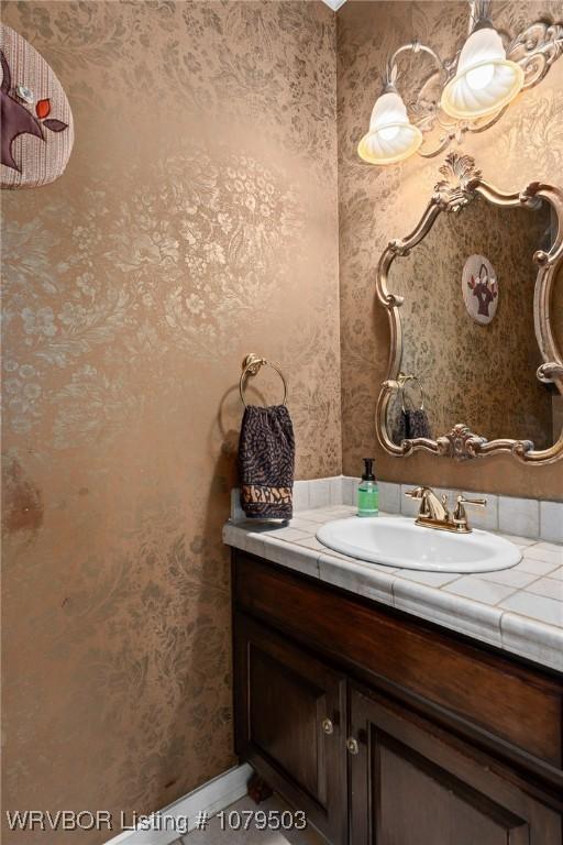 bathroom featuring vanity and wallpapered walls