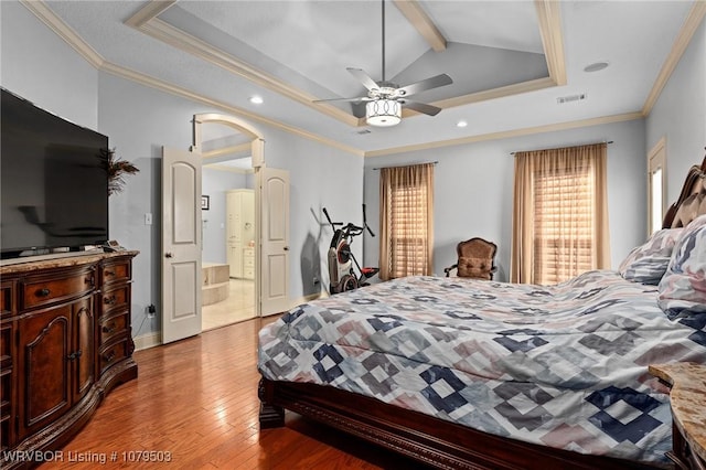 bedroom with ornamental molding, a tray ceiling, and hardwood / wood-style floors