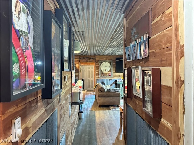 hallway featuring hardwood / wood-style flooring and wooden walls